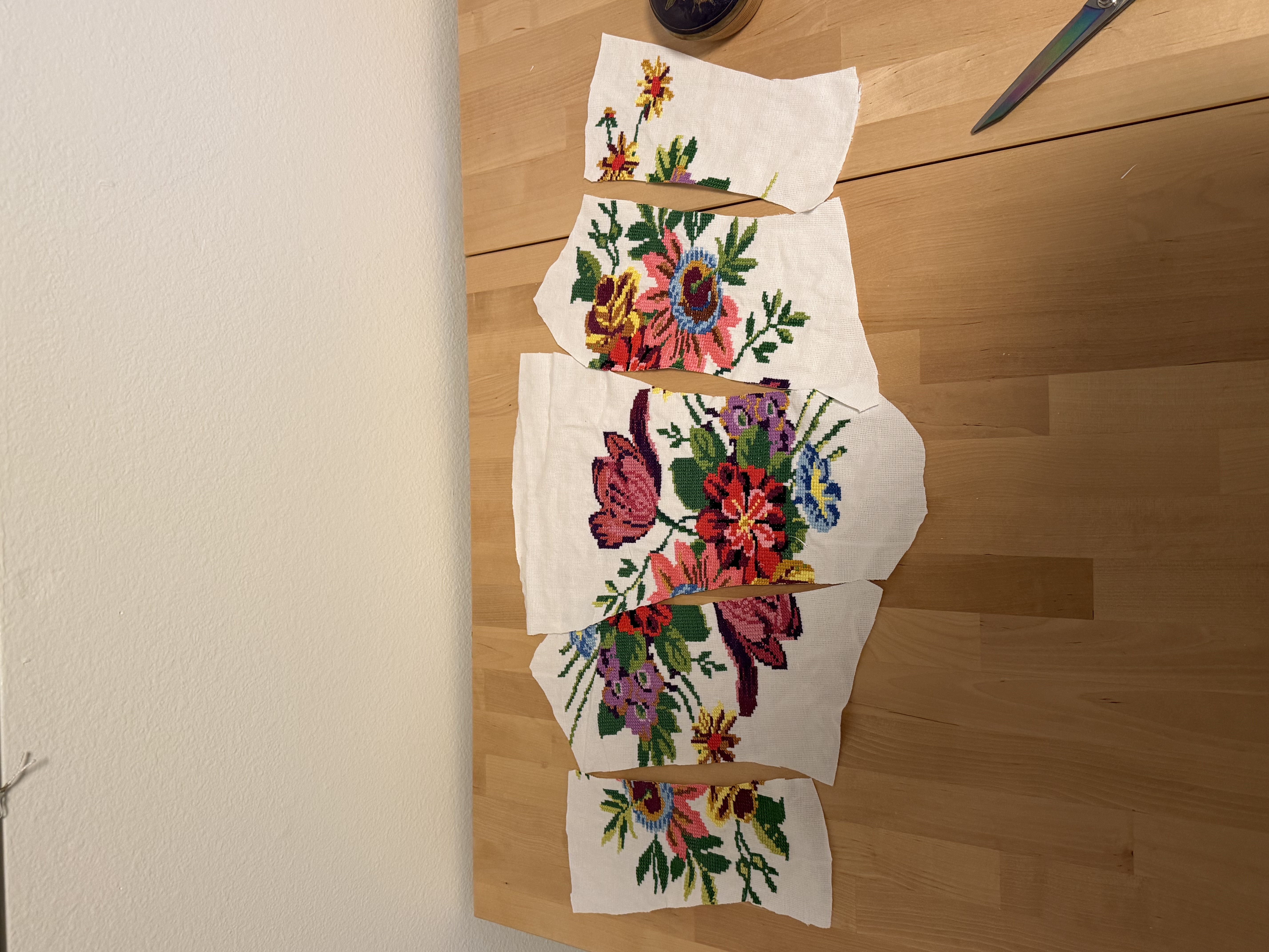 Pattern pieces cut from the pillowcases, needlepoint designs staggered across the panels